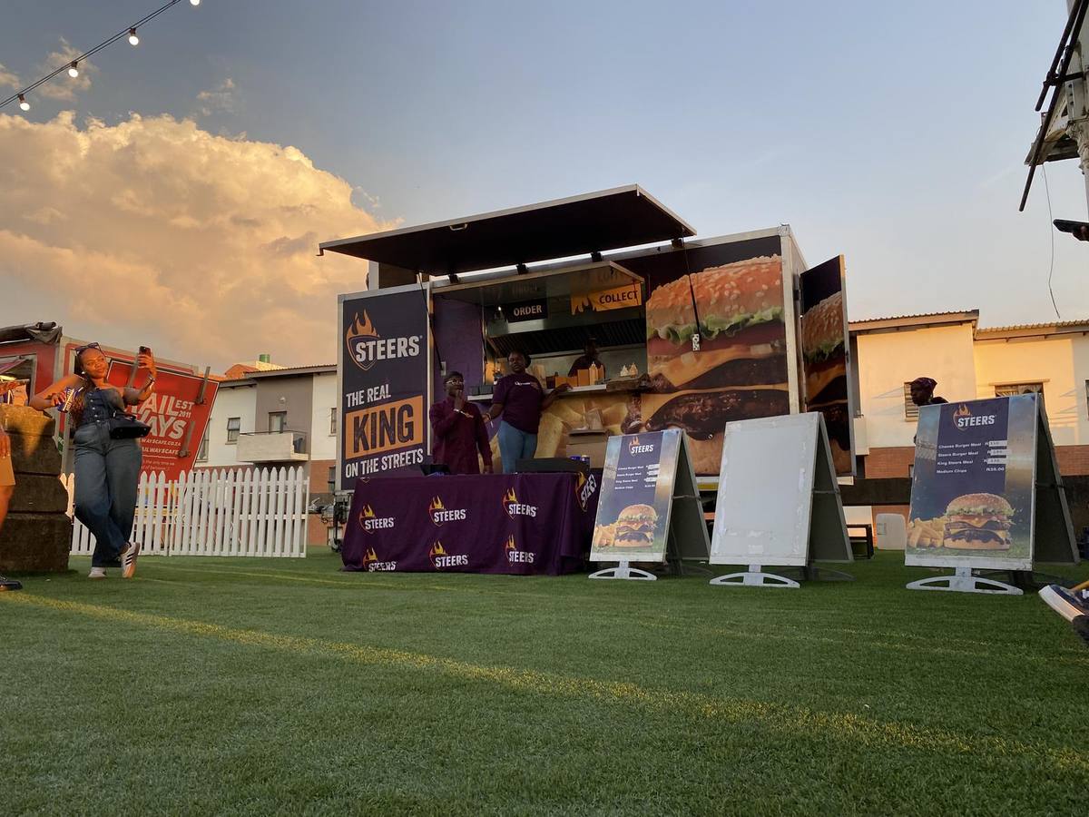 Flame Grilled Events trailer serving guests at sunset